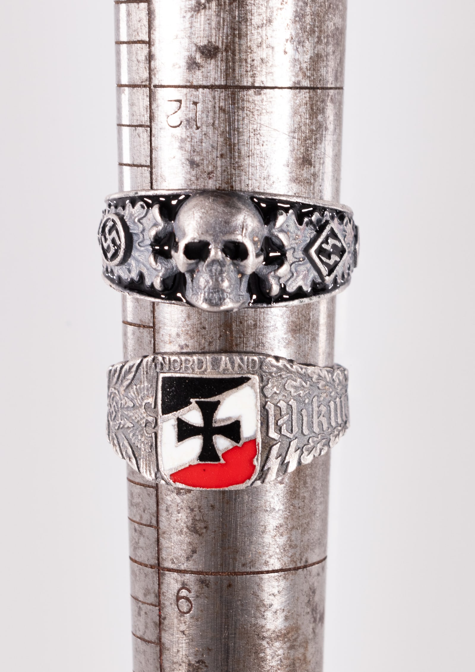 GERMAN WAFFEN-SS RINGS (2): Lot of two German Waffen-SS rings, a skull and crossbones 'Totenkopf' ring, silver, enameled with black, featuring a skull and crossbones on the face flanked by runes and engraved runes on the inside 