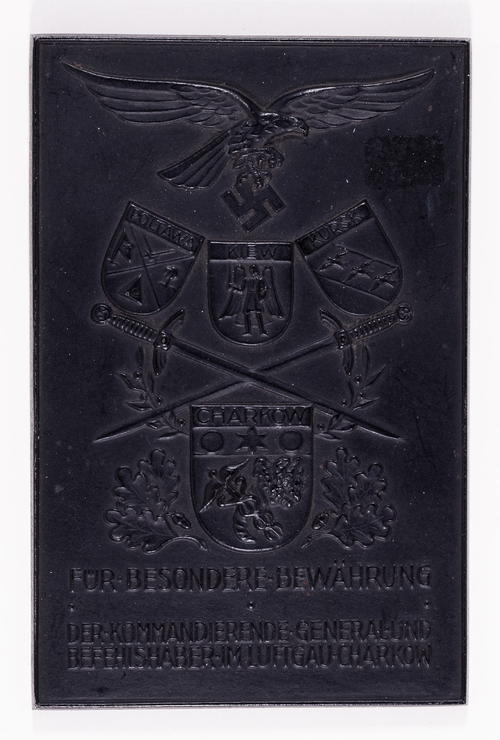 GERMAN WWII CHERKOW WALL PLAQUE: A wall plaque to commemorate the victory of the German Wehrmacht at Kharkov in WWII. The plaque shows an eagle clutching a swastika with the crossed swords in the center with the towns 'Poltawa' 'Kiew