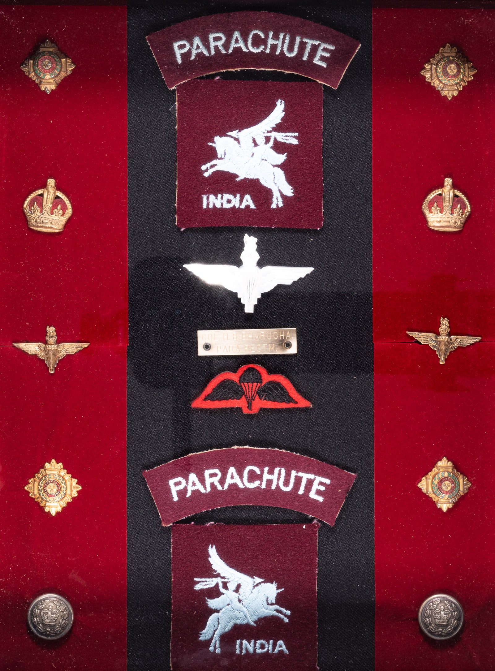 BRITISH INDIA PARACHUTE REGIMENT INSIGNIA DISPLAY: British India Parachute regiment insignia display, includes four British India collar pips, two British crown badges, two shirt buttons, two parachutist collar pips, a British India jump wings badge, 