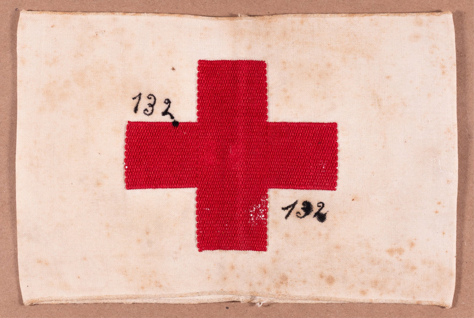 WWII GERMAN RED CROSS ARMBAND: WWII German Red Cross armband stamped Waffen-SS Panzer Division Wiking. White cotton armband embroidered with a red cross and the number 132 written on it. Stamped twice on the inside. Ends sewn toget