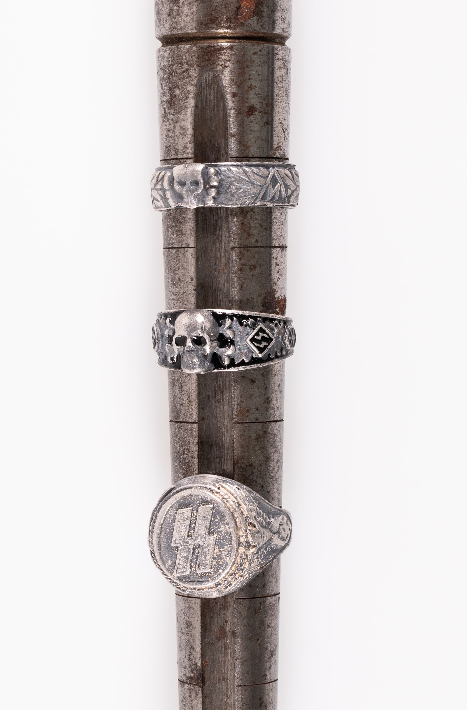 3 GERMAN WAFFEN-SS TOTENKOPF RINGS: Lot of three German Waffen-SS rings. One ring with 'SS' runes on top and an eagle holding a swastika on the sides, one with a skull in the top center with laurel leaves and runes around the band, and 