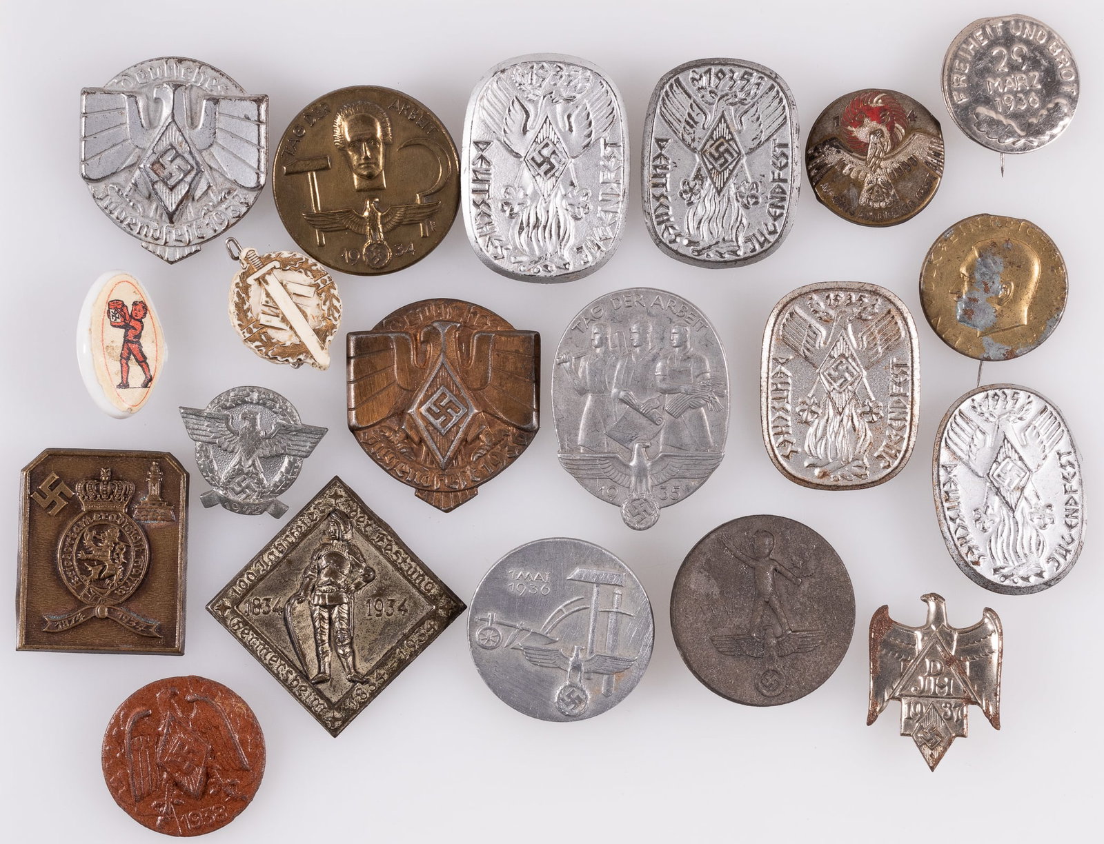 20 GERMAN THIRD REICH TINNIES AND BADGES: Lot of twenty German Third Reich tinnies and badges, including Hitler Youth tinnies, Hitler tinnies, party rally tinnies, and others. Pinback badges, some pins missing. Sold as-is.