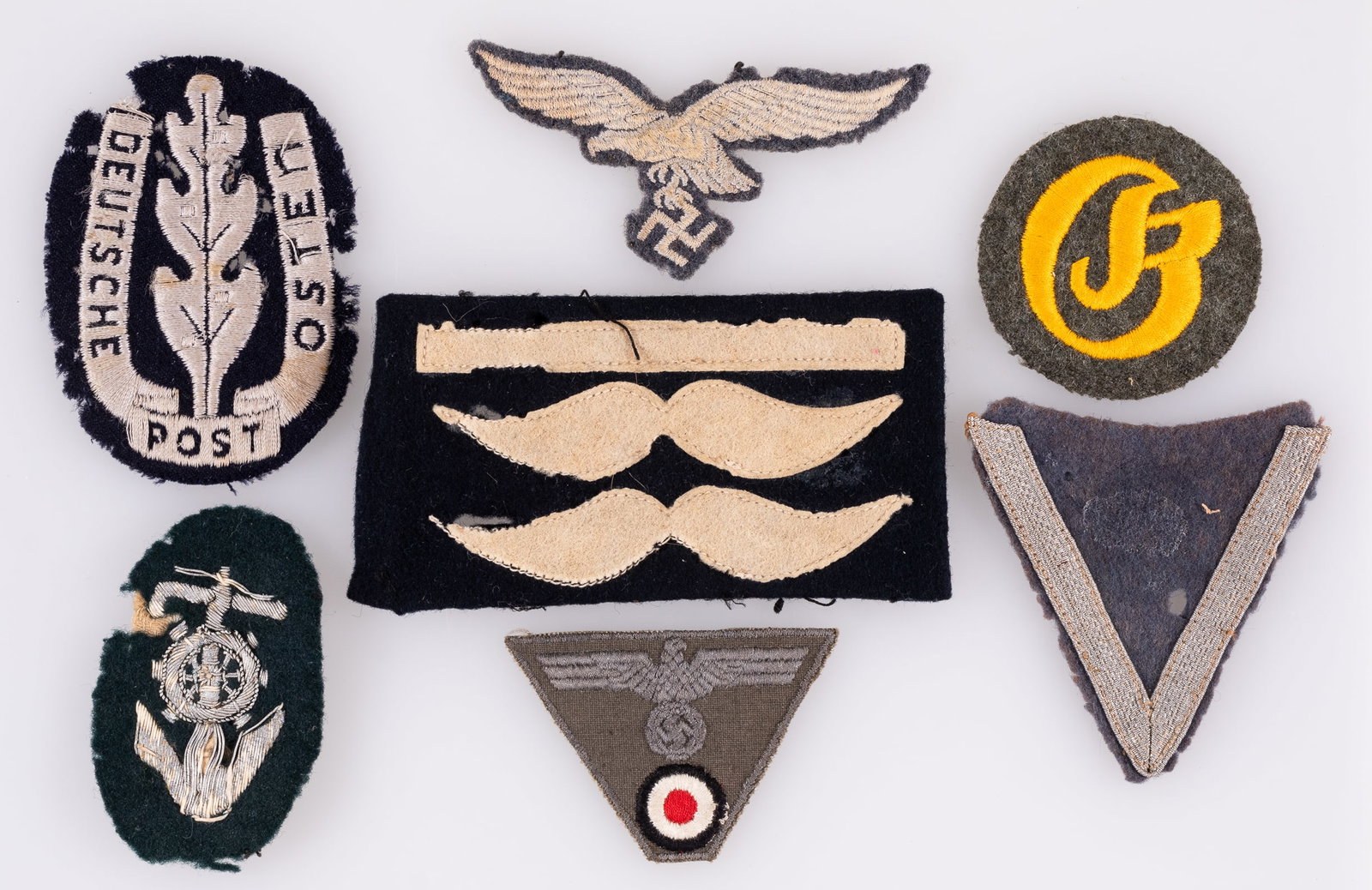 7 WWII GERMAN INSIGNIA PATCHES: Seven WWII German insignia and rank patches, including the RMBO chest patch, some insect damage throughout, Supply Administration Trade shoulder patch, late war M43 trapezoid cap badge patch, Armelabz