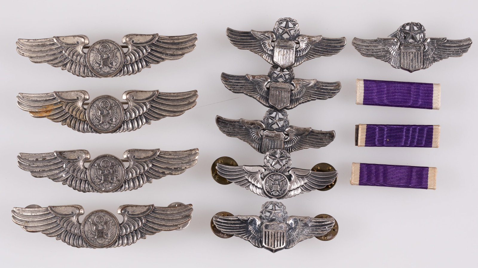 10 AMERICAN PILOT AND AIR CREW WINGS: Ten American pilot wings and air crew wings badges, including five Command Pilot wings, four Aircrew wings, and one Master Aircrew wings. Also includes three Purple Heart medal ribbons. Each set of wi