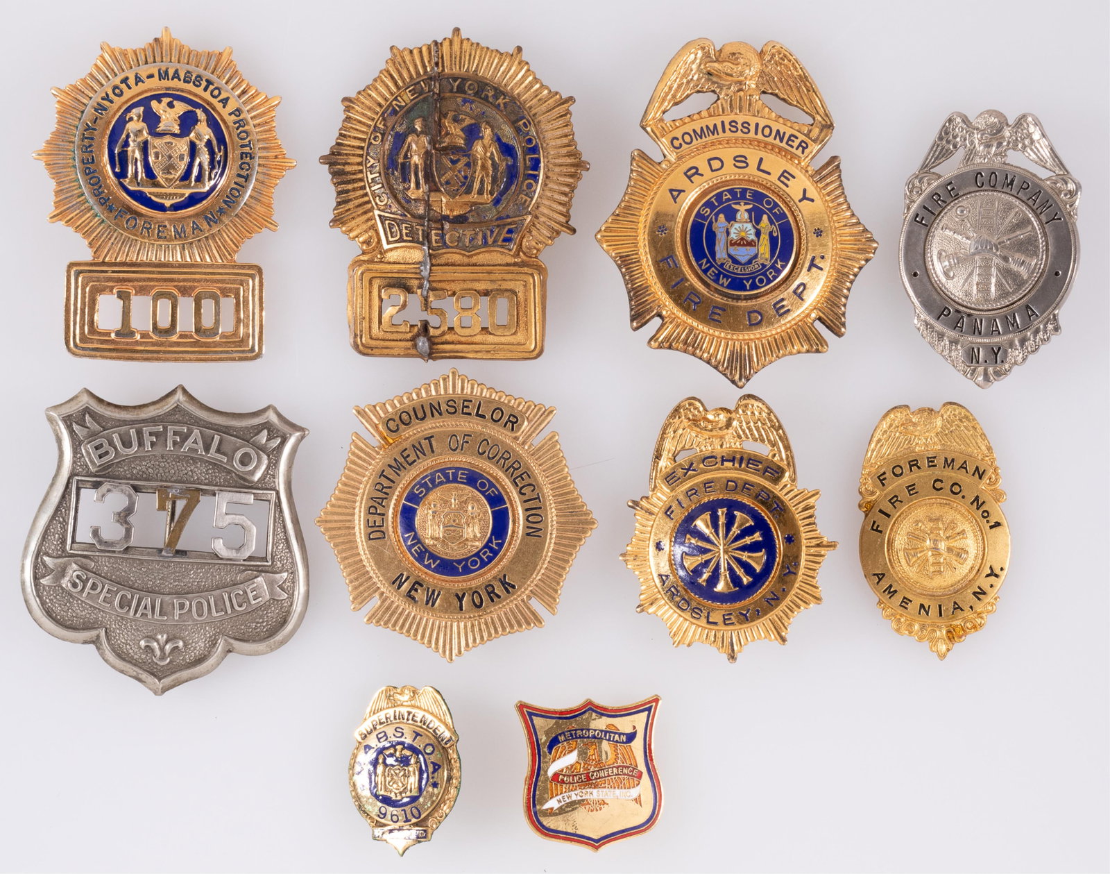 11 OBSOLETE NEW YORK SERVICES BADGES: Eleven obsolete New York services badges, including a Buffalo Special Police badge, Department of Corrections Counselor badge, an Ardsley Fire Commissioner badge, an Ardsley Ex Chief badge, a Panama F