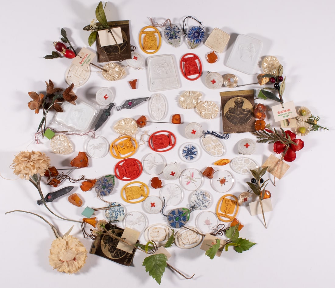 125 WHW WINTERHILFSWERK DONATION TOKENS: Approx. 125 WHW Winterhilfswerk donation tokens, including many glass tokens featuring Hitler Youth insignia, pond animals, and flowers, some amber stick pins, and some fake flowers. Some missing thei