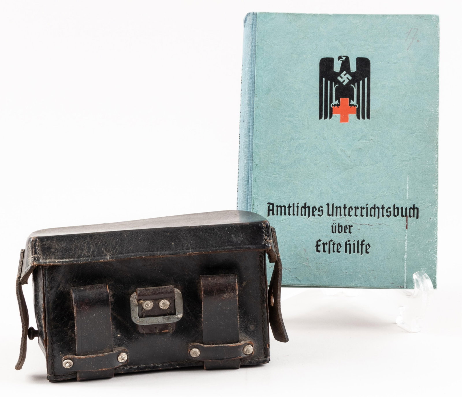 WWII GERMAN RED CROSS FIELD FIRST AID KIT AND OFFICIAL MANUAL: WWII German Red Cross field first aid kit and official manual, including the first aid kit, stamped on the front 'DLWP 1940,' and on the inside lid 'D.R.K. Sanitatslager Babelsberg.' Black leather kit