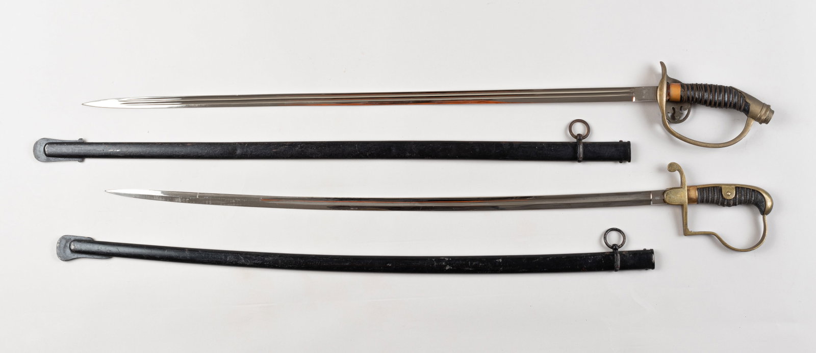 WWI IMPERIAL GERMAN OFFICER SWORDS: Two WWI Imperial German officer swords, including a Bavarian Infantry officer sword with scabbard, brass colored pommel and handguard with black grips, no markings on the blade. Also includes an M1889