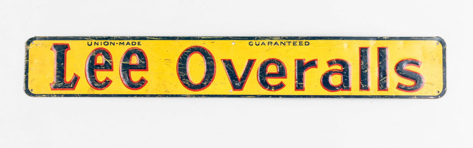VINTAGE LEE OVERALLS ADVERTISEMENT SIGN: Vintage Lee Overalls advertisement sign, reads 'Union-Made Guaranteed Lee Overalls,' blue, red, and yellow magnetic steel sign, six holes along the margins to hang the sign, scratching and some dentin