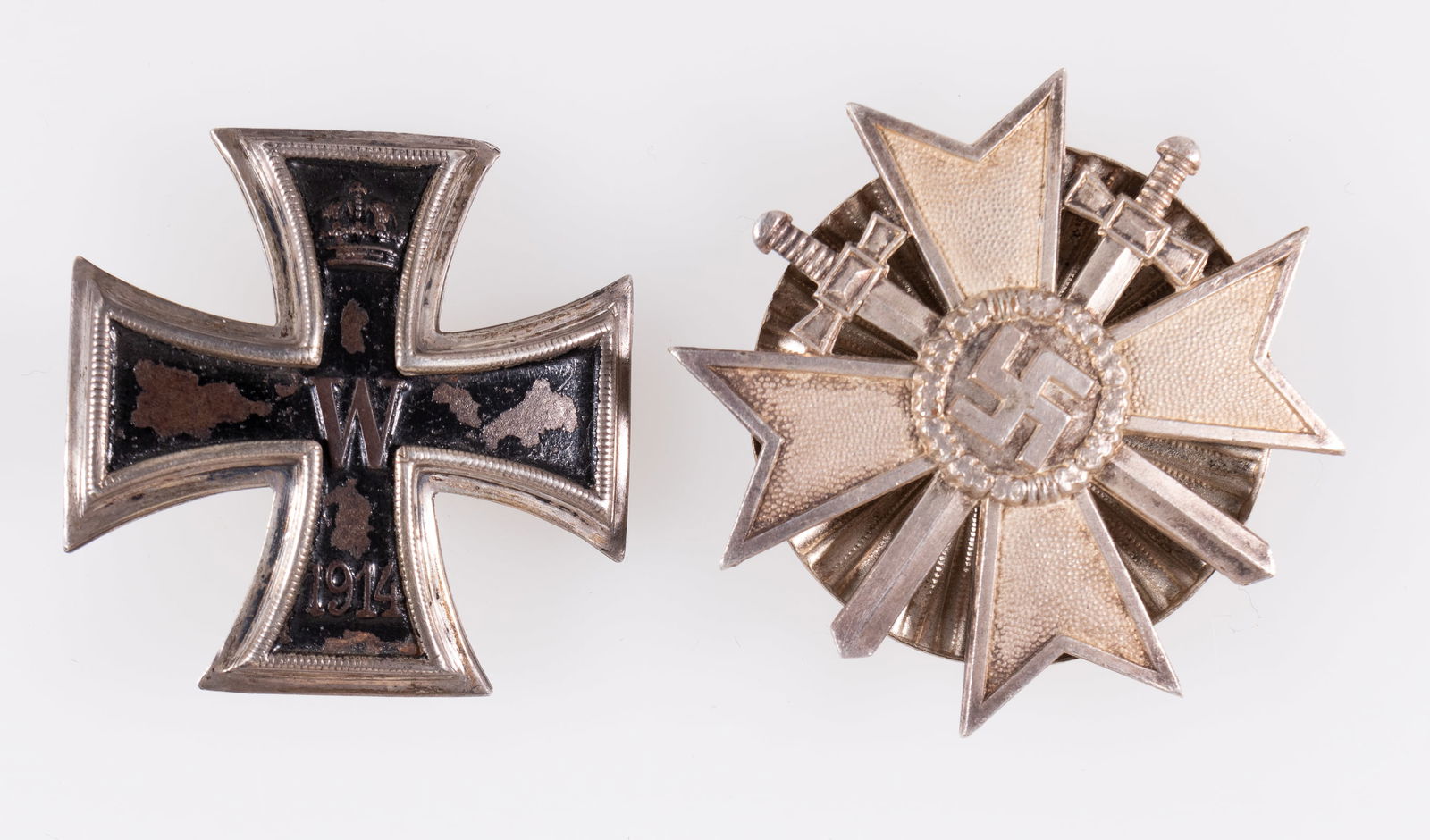 2 GERMAN MEDALS [WWI / WWII]: Two German medals from WWI and WWII, including the WWI Iron Cross 2nd Class, broken pinback, marked under the catch 'KO' for the well-documented unknown maker of WWI badges, and the WWII War Merit Cro