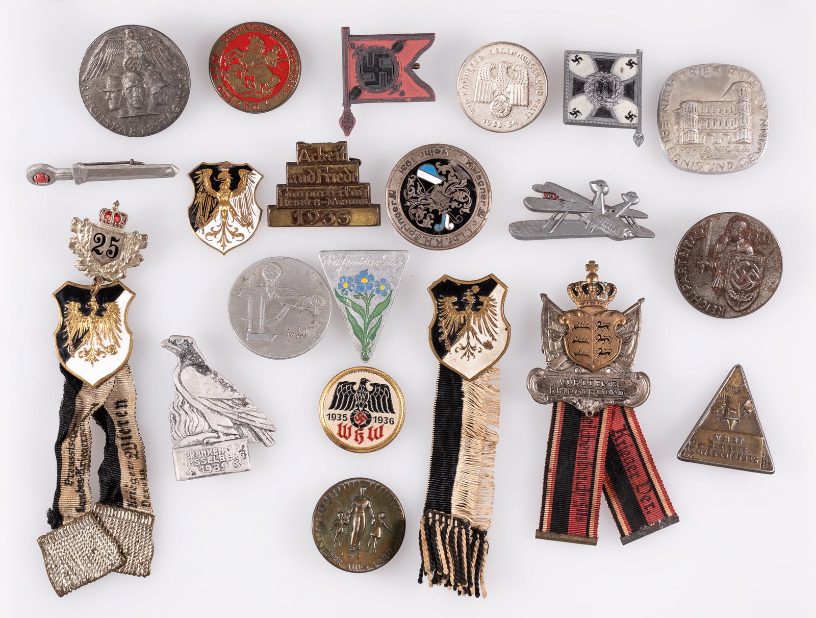 20 WWI / WWII GERMAN DONATION TINNIES AND BADGES: Twenty WWI and WWII German donation tinnies and badges, including four WWI Prussian badges, one long service badge and one Wurttemb Kriegerbund badge, two WHW regimental flag donation tokens, a Party 
