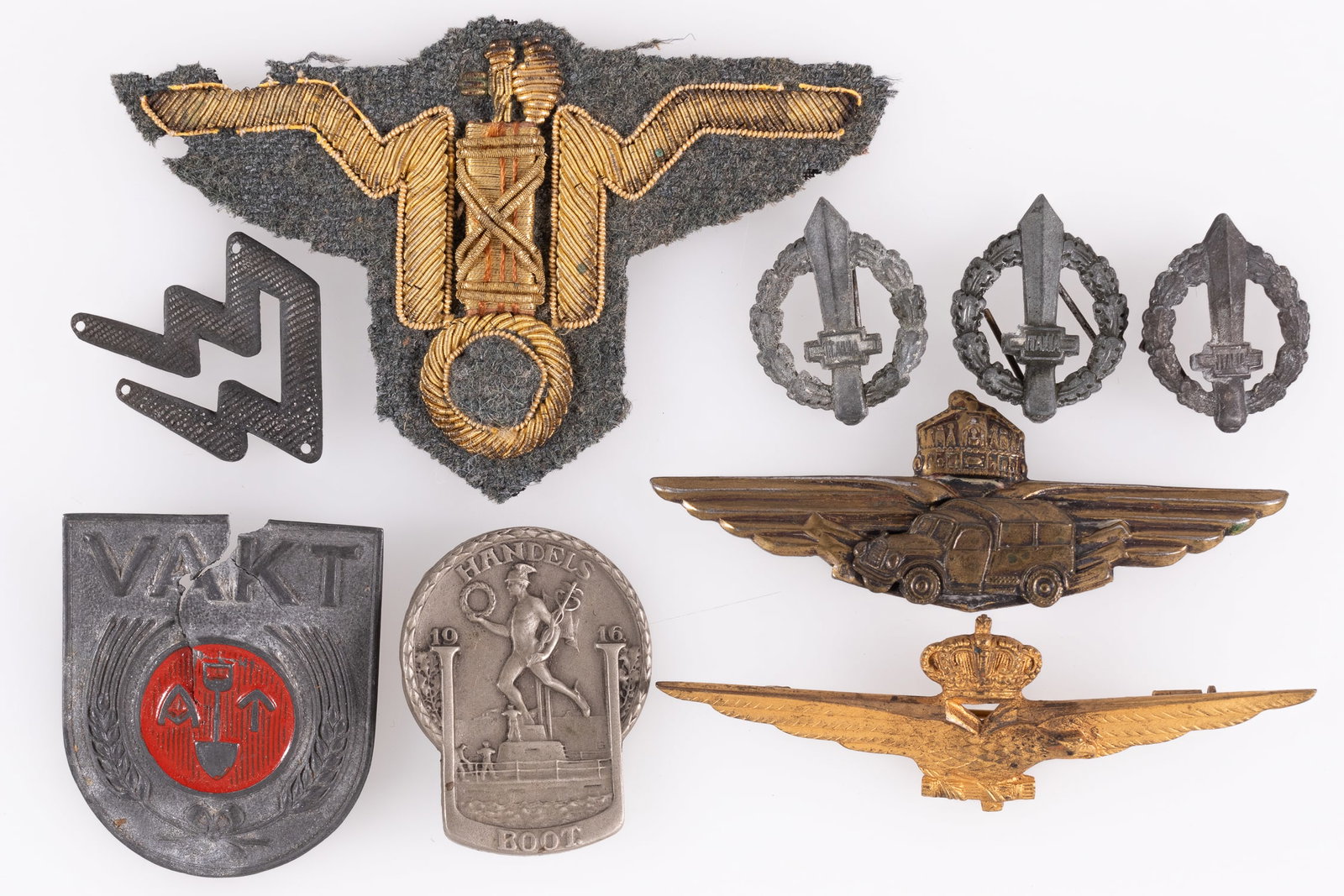 9 WWII FASCIST BADGES AND INSIGNIA: Nine WWII fascist badges and insignia, including Fascist Italian Pilot wings, Italian GNR officers cap badge, three PNF collar tab badges, an Austrian WWI U-Boat badge, Hungarian Truck Drivers badge, 