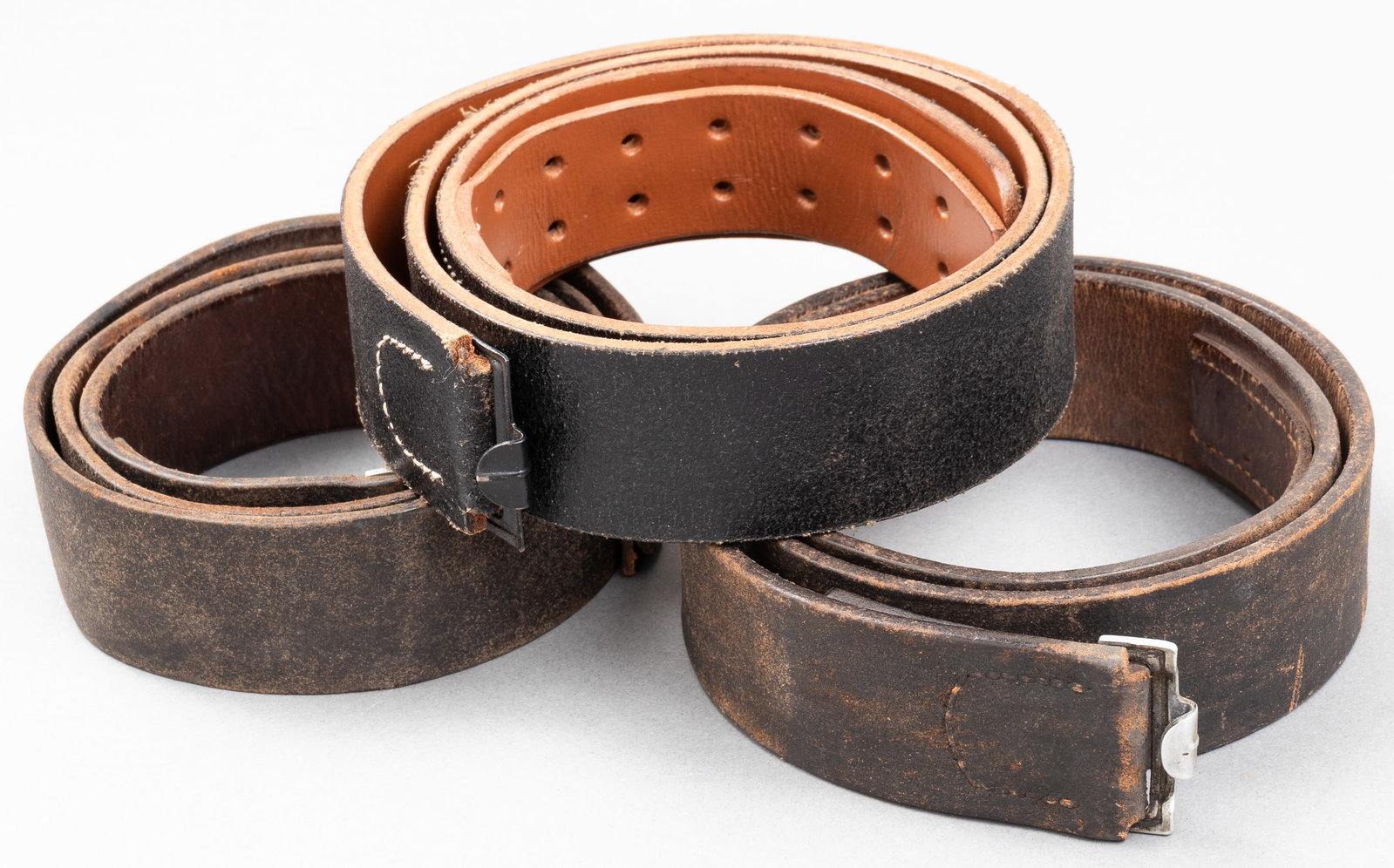 3 WWII GERMAN ARMY LEATHER BELTS: Three WWII German army leather belts, one marked 'B. A. B. 739' on the inside with a previous owner's name written in red ink, one marked 'B.A.S. 839' with '95' marked on the end, and one unmarked. Ap