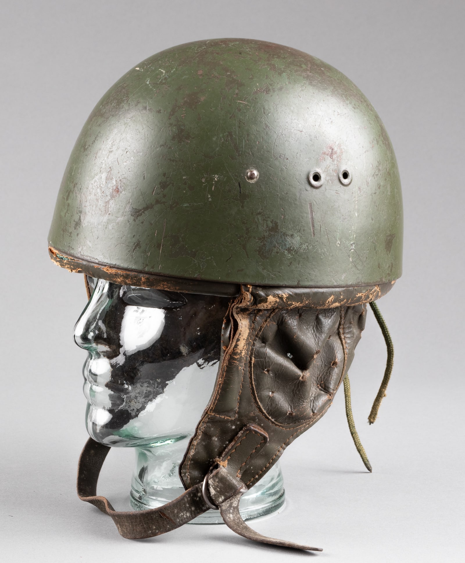 EAST GERMAN / POLISH PARATROOPERS HELMET: East German / Polish paratroopers helmet with leather liner and chinstrap with ear covers, wear to the leather, no markings visible on the inside.