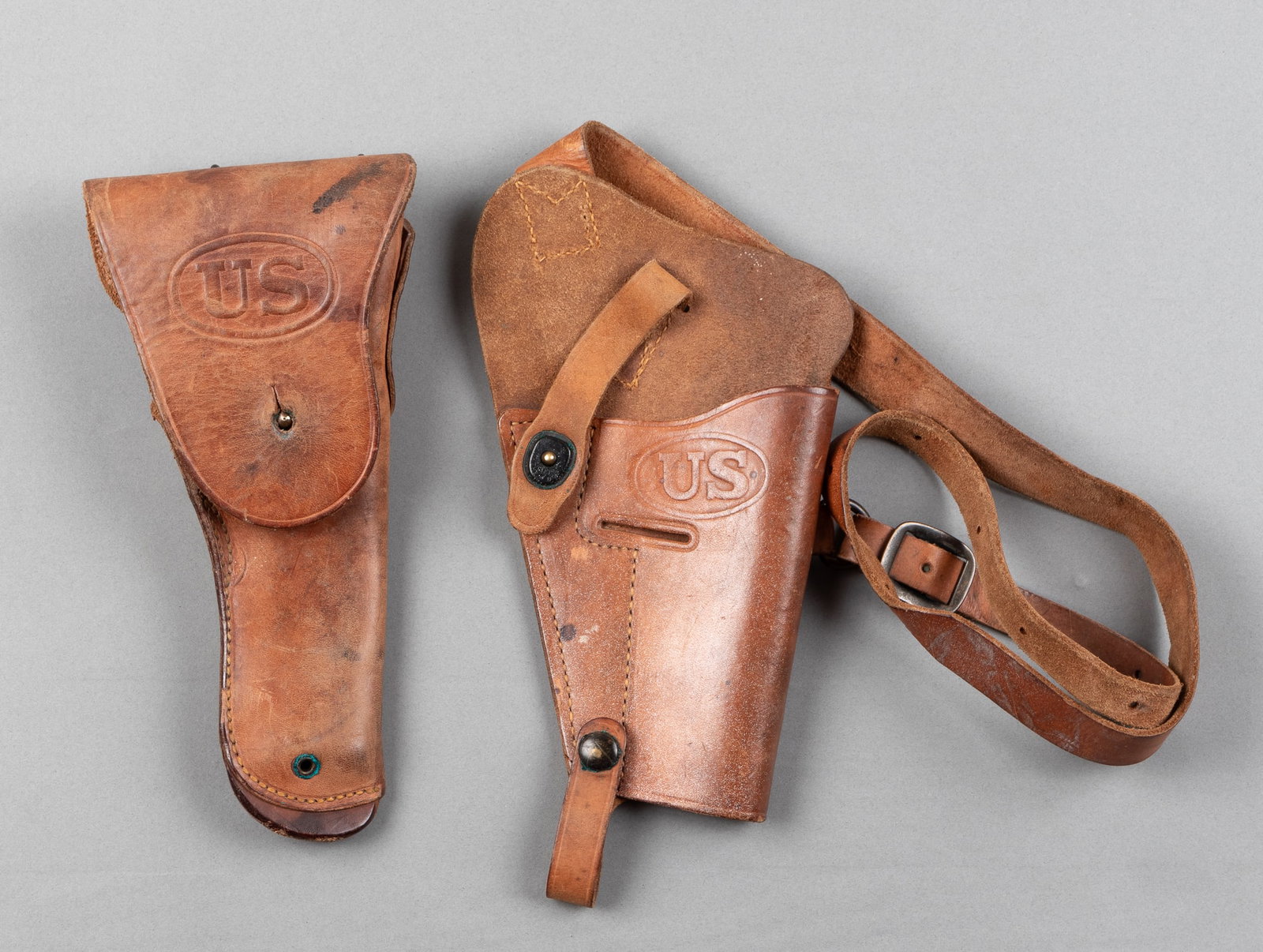 2 WWII AMERICAN PISTOL HOLSTERS: Two WWII American pistol holsters, including a M1916 sidearm holster, marked on the reverse 'Milwaukee Saddlery Co. 1942.' Along with a M3 shoulder holster, stamped on the reverse 'U.S. Bovt.' Both le