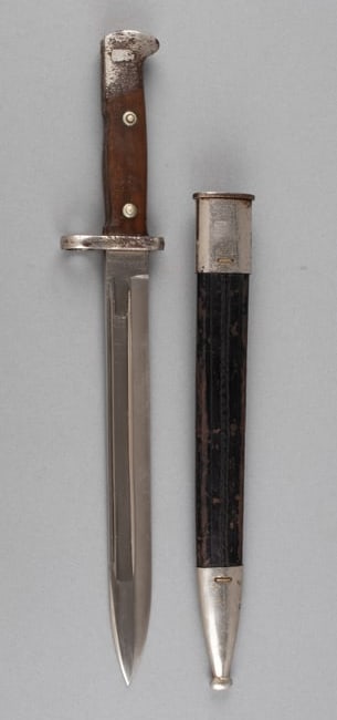 GERMAN WKC K98 DRESS BAYONET W/ SCABBARD: German K98 bayonet with leather scabbard, knight head maker mark stamped on the ricasso for maker W.K.C. Leather scabbard unmarked, wear to the leather, and scratching to the metal. 10-inch long blade