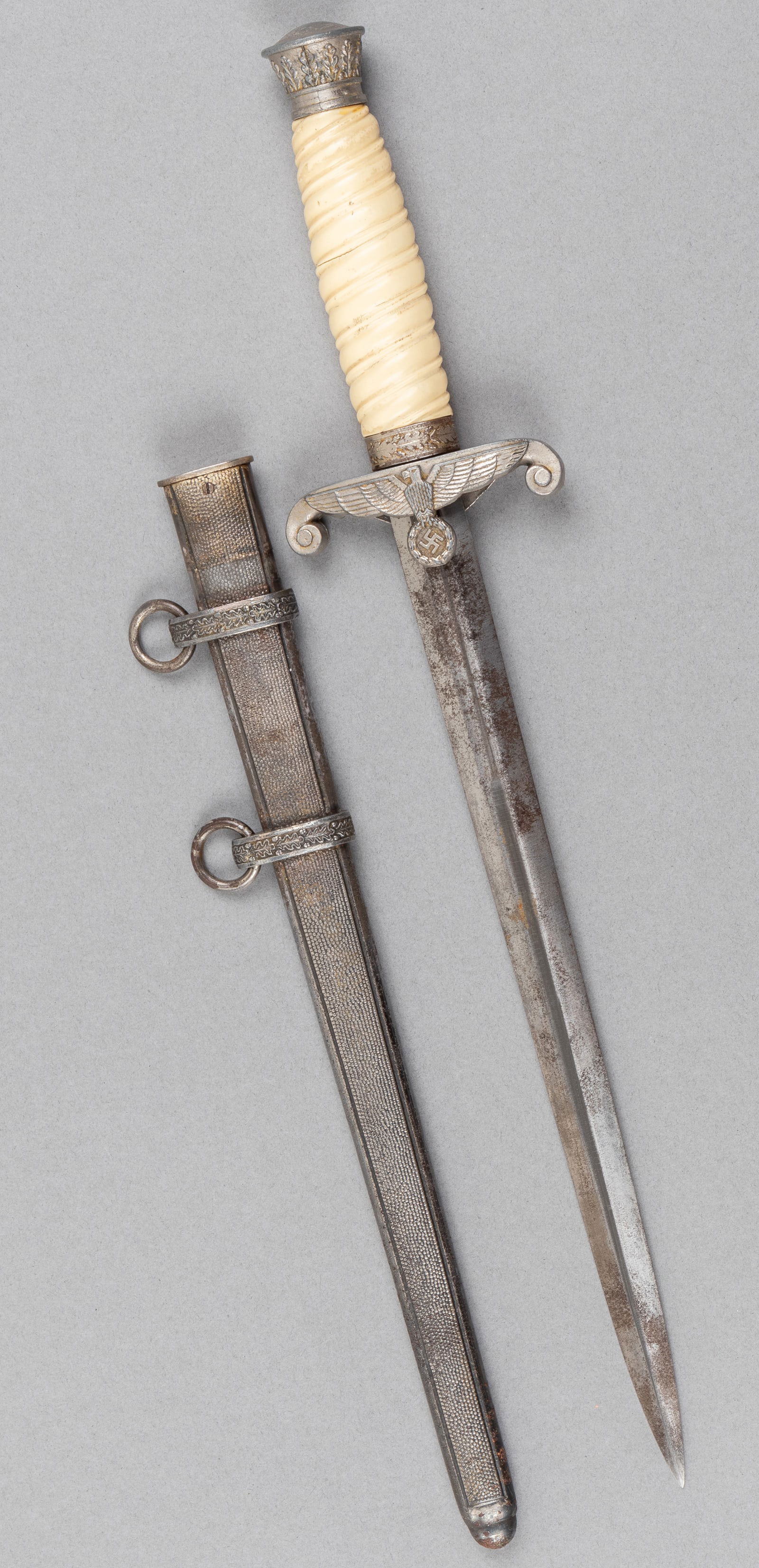 WWII GERMAN ARMY OFFICERS DAGGER UNMARKED: WWII German Army Officers' dagger, unmarked, white plastic handgrip, and a cross guard featuring the German eagle holding a swastika. 10.25-inch long blade, pitting throughout, likely a late model dag