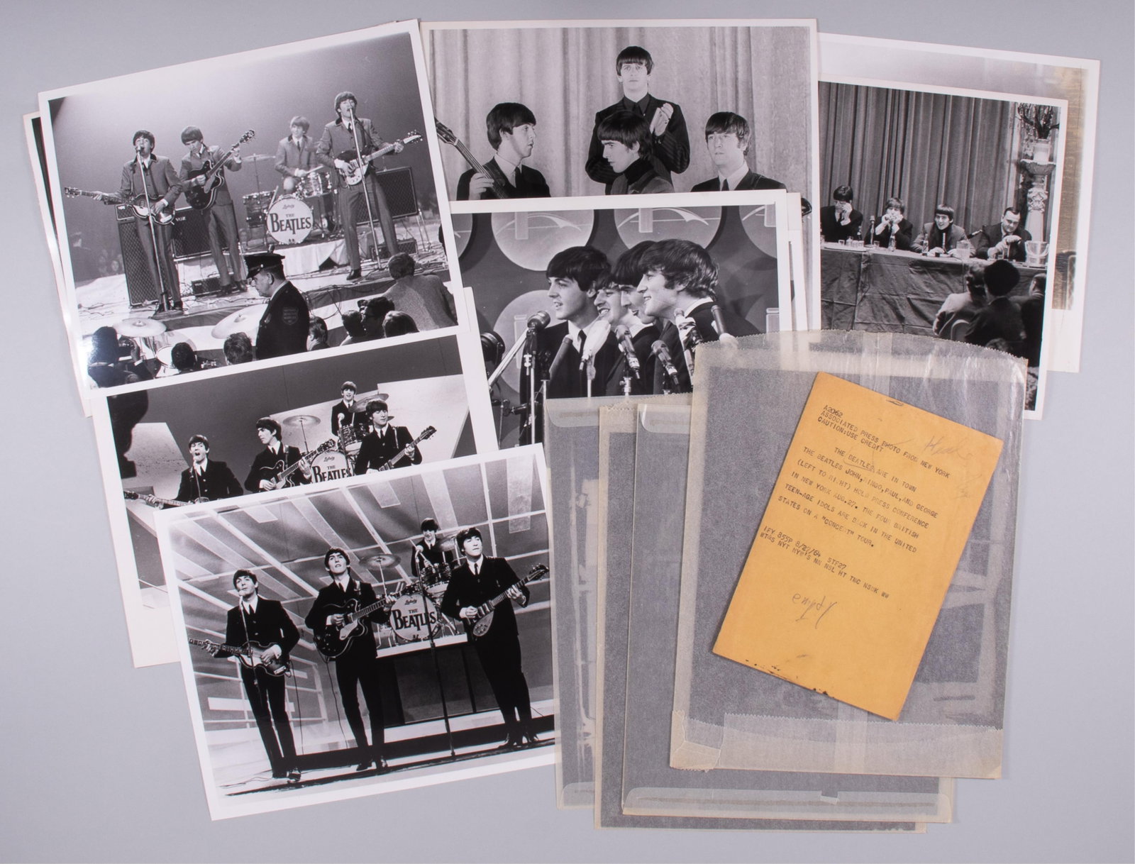 15 THE BEATLES NEGATIVES AND PHOTOGRAPHS: Fifteen The Beatles negatives and photos, including four 8 x 10 inch negatives with the four b/w images they were made from, with four photos of the group performing, two photographs of them at confer
