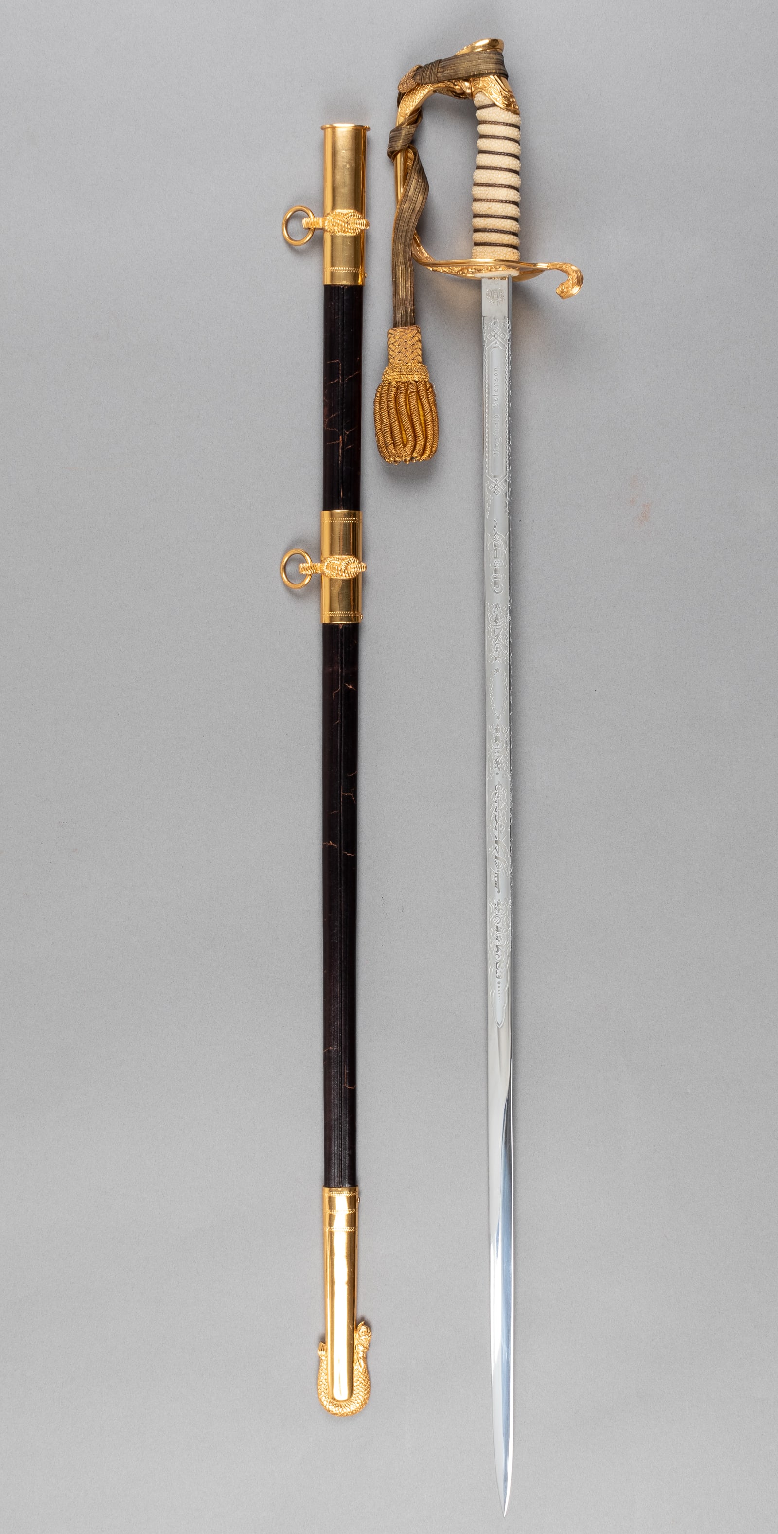NAMED US NAVY OFFICERS SWORD: US Navy Officer's sword with cloth cover, named to Reginald Peterson on the blade, marked on the ricasso for maker 'Japan Sword Co. Ltd.,' decorative gold knuckle guard, a shagreen grip, wrapped aroun