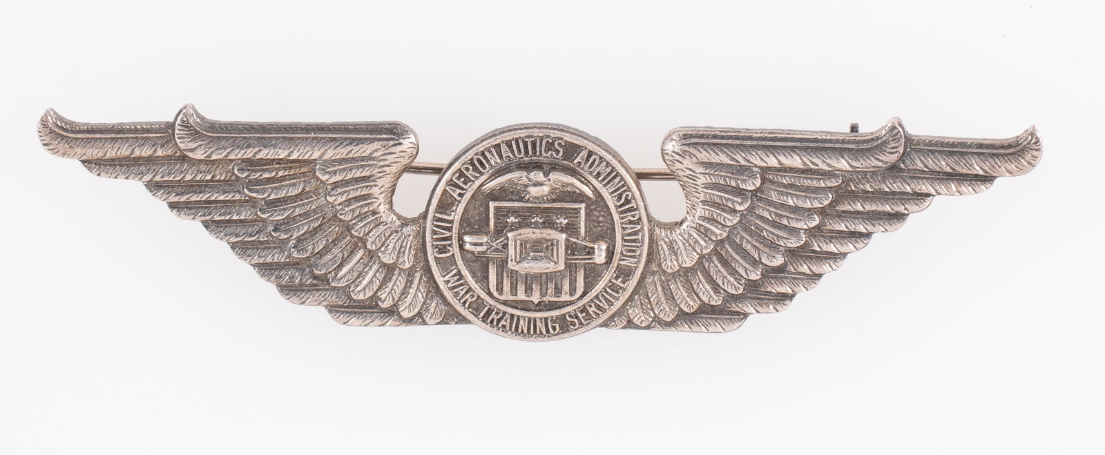 WWII CAA WAR TRAINING STERLING WINGS: WWII-era US Civil Aeronautics Administration War Training Service sterling pilot wings badge, c-clasp pinback, marked 'PAT. PEND. STERLING' on the reverse, 3 inches long.