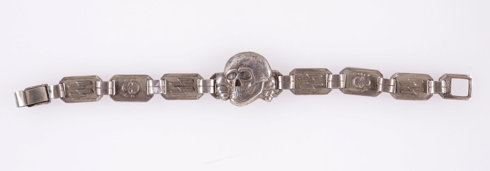 WAFFEN-SS TOTENKOPF BRACELET: Waffen-SS Totenkopf insignia bracelet, with a large Totenkopf skull in the center, and SS runes and a smaller Totenkopf on the bracelet band. On the reverse of one of the links is stamped 'KH,' with m