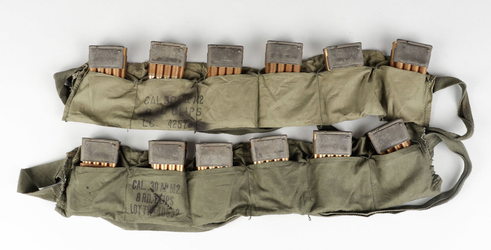 96 ROUNDS CAL 30 BALL M2 8 RD: Two Vietnam War M1 Garand bandoliers, each with 48 rounds of ammunition in clips, marked in black ink on each, 'Cal .30 Ball M2 8 RD Clips,' one with a stamp dating October 1967, and o
