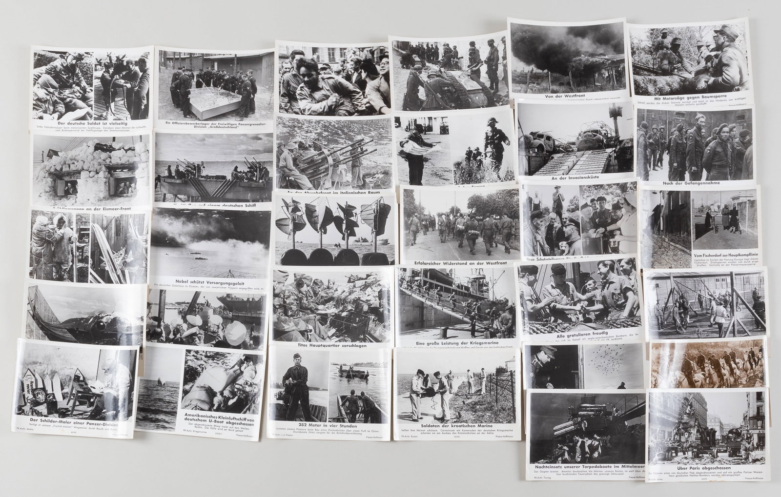 32 THIRD REICH WEHRMACHT HEINRICH HOFFMAN PHOTOGRAPHS: 32 original black-and-white glossy photographs published by Heinrich Hoffmann. Photos show soldiers on the front lines, Italy, the Alps, in snowy environments, a seaplane base, a port of operations in