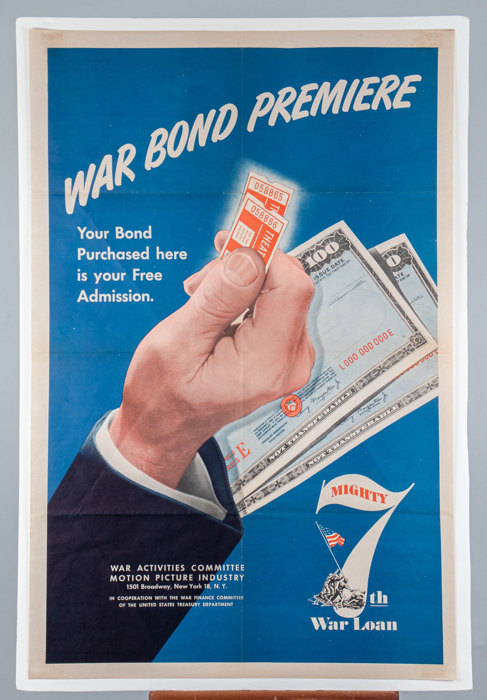 WWII WAR BOND PREMIERE POSTER: 'War Bond Premiere / Your Bond Purchased here is your Free Admission / Mighty 7th War Loan,' War Activities Committee Motion Picture Industry, 1944. Folds. 27 x 41 inches.