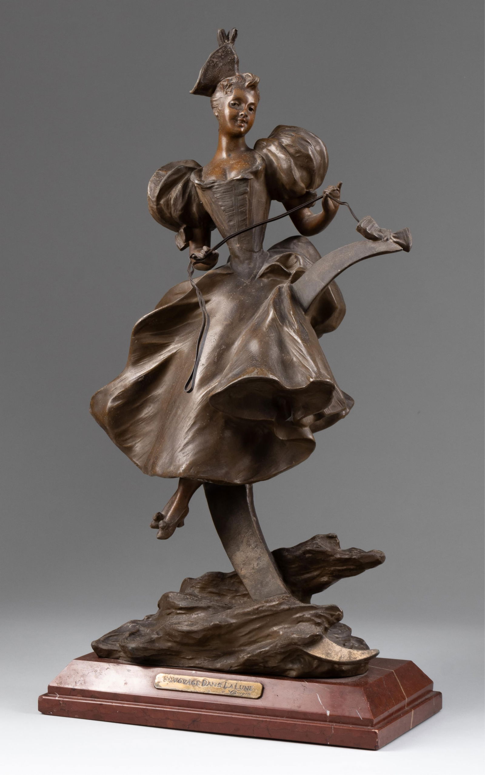 VICTOR LEOPOLD BRUYNEEL - VOYAGE DANS LA NUIT: 'Journey into the Night,' patinated spelter sculpture by Victor Leopold Bruyneel (b. 1859), attached to a pink marble base, features an elegant woman riding the moon, 21.5 x 11.75 x 10.5 inches.