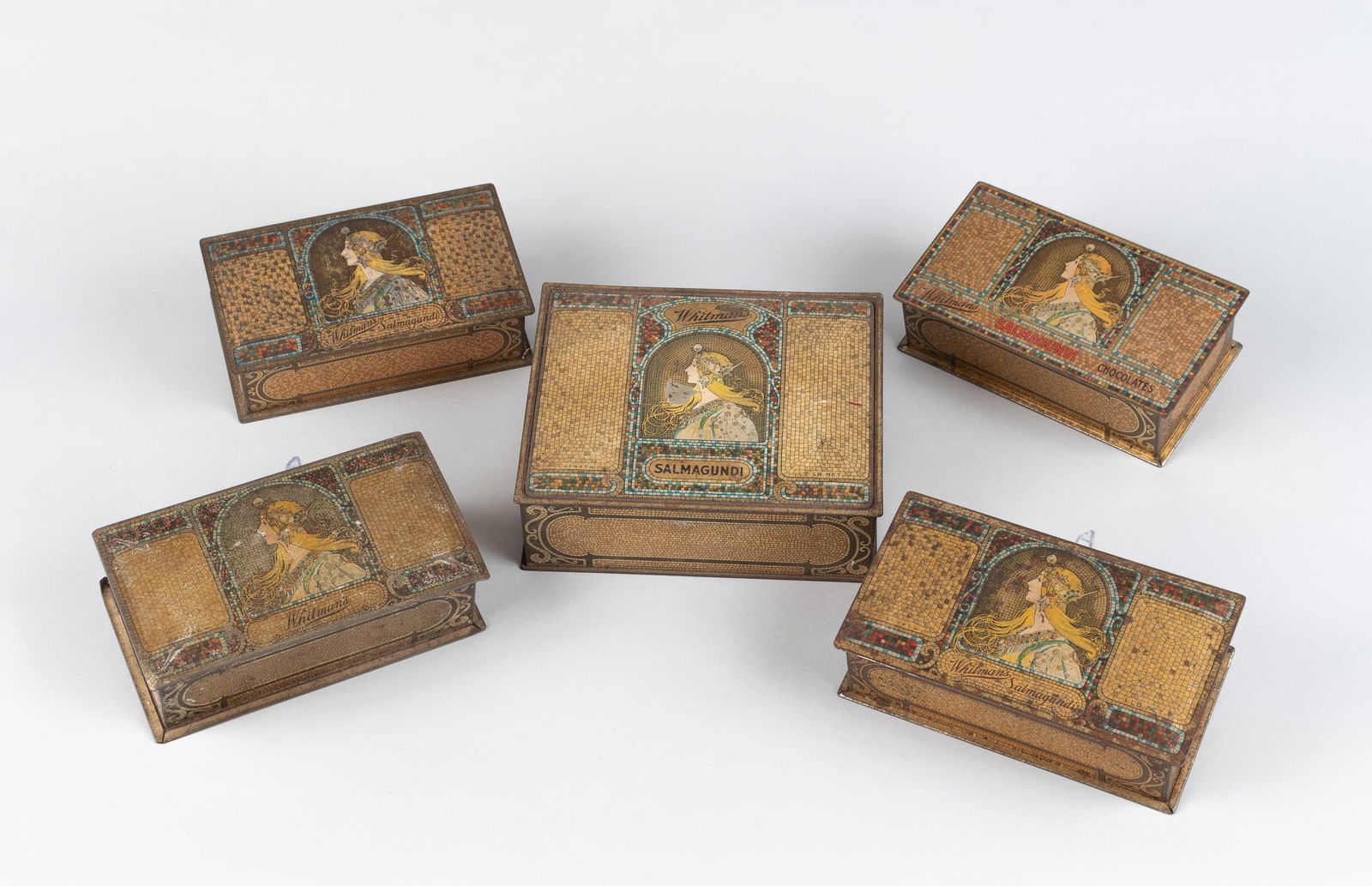 ALPHONSE MUCHA - 5 WHITMANS SALMANGUNDI CHOCOLATE TINS: Group of five Whitmans Salmangundi chocolate tins from the 1920s, comprising four 1-lb tins and one larger 2-lb tin. Each features a vivid polychrome mosaic design after The Zodiac (1896), the