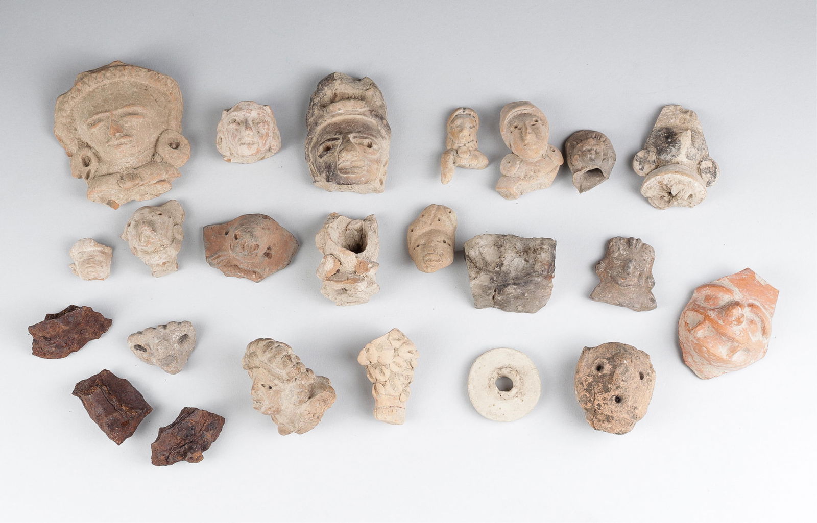 PRE-COLUMBIAN NAYARIT AND JALISCO POTTERY HEADS: Collection of Pre-Columbian Nayarit and Jalisco pottery figure heads, each a broken portion of a pottery figure; one piece is a circular stand, and one piece looks like an animal leg piece. Also