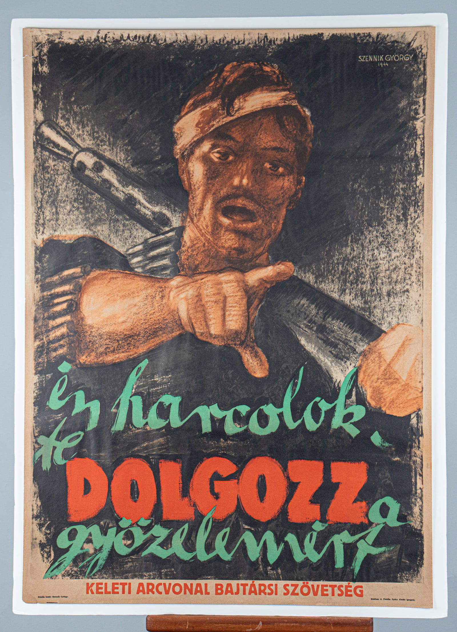 WWII WAFFEN-SS GYORGY SZENNIK POSTER: Hungarian 'Waffen-SS' poster, 'I Fight, You Must Work for Victory!', artwork by Gyorgy Szennik (1923-2007), printed by Alliance of Eastern Front Veterans, 1944, 39.75 x 28.5 inches. 2-inch tear on