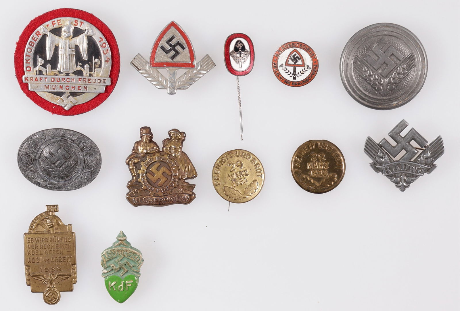 12 WWII GERMAN RAD, KDF, DAF BADGES AND TINNIES: Twelve WWII German badges and tinnies, including a RAD Party Membership badge, marked '37 Ges Gesch RJAD,' a RAD Cap Badge, marked on the reverse 'C.T.D. 39 Ges Gesch RLAD,' a RAD stick pin, marked 'R