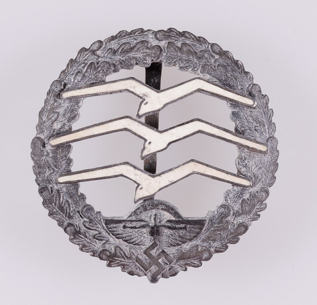 NSFK GLIDER PILOT BADGE: German Third Reich NSFK glider pilots badge, zinc construction with three birds applied on the front, each painted white. On the reverse is marked 'Eigentum des NS-Fliegerkorps - Ges.Gesch. 29240 - 55