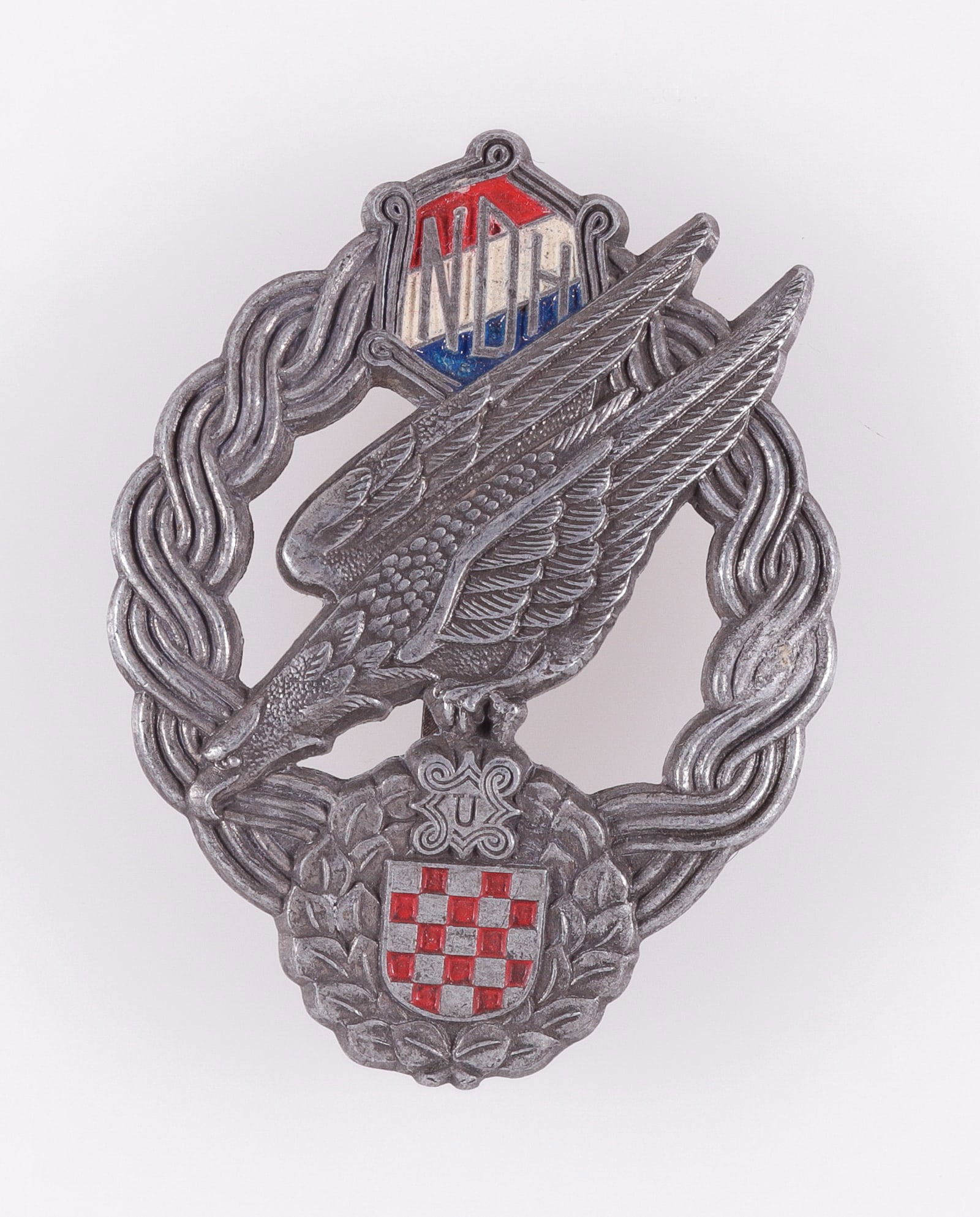 WWII CROATIAN USTASE LUFTWAFFE PARATROOPER BADGE: WWII Croatian Ustase Luftwaffe paratroopers badge, marked on the reverse 'Braca Knaus Zagreb,' for the Knaus Brothers in Zagreb, at the top reads NDH with the Ustase insignia at the bottom. 53 x 40 mm