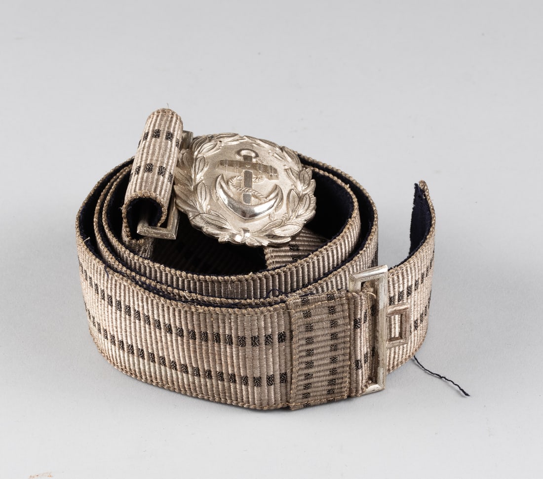 WWII GERMAN KRIEGSMARINE OFFICERS' BELT AND BUCKLE: WWII German Kriegsmarine Officers' belt and buckle. Administrative Officers' silvered aluminum construction buckle, unmarked on the reverse, featuring an anchor within an oak leaf wreath. With a broca