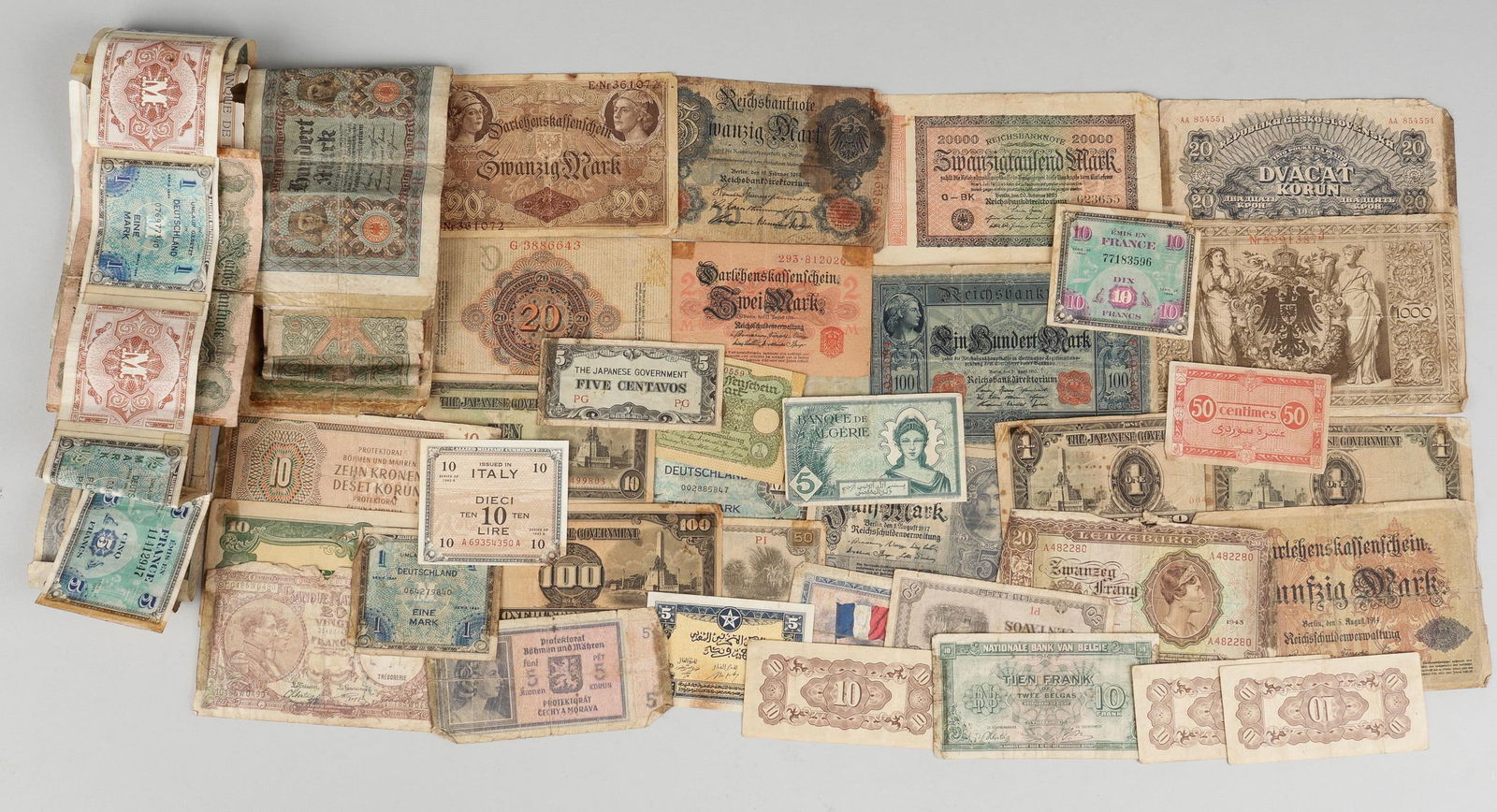 WWII GERMAN HITLER YOUTH TINNIES, BUTTONS, & OCCUPATION BILLS: Mixed lot of one Hitler Youth tinnie, a DLRG stick pin, seven HJ/DJ brown shirt buttons each marked with the RZM mark on the reverse, one SA uniform button, marked on the back for Assmann, and a colle