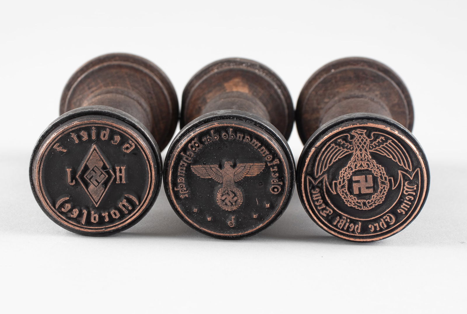 3 WWII NAZI HANDSTAMPS: Three WWII Nazi wooden handstamps, one reads 'Gebiet 7 H J (Nordsee),' with the Hitler Youth diamond in the center, one reads 'Oberkommando der Wehrmacht b,' with a Reichsadler eagle in the center,