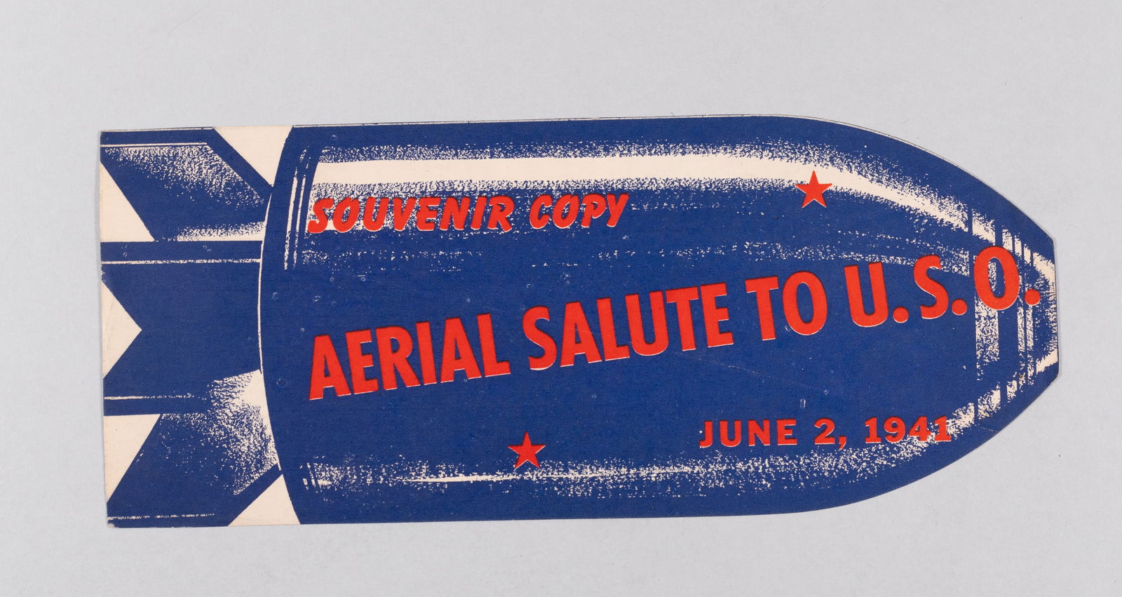 WWII HOMEFRONT PROPAGANDA LEAFLET AERIAL SALUTE TO U.S.O.: WWII American Homefront propaganda leaflet. In the shape of a bomb, one side reads 'Souvenir Copy / Aerial Salute to U.S.O. / June 2, 1941.' The reverse reads in part, 'No... This isn't a Bomb / It