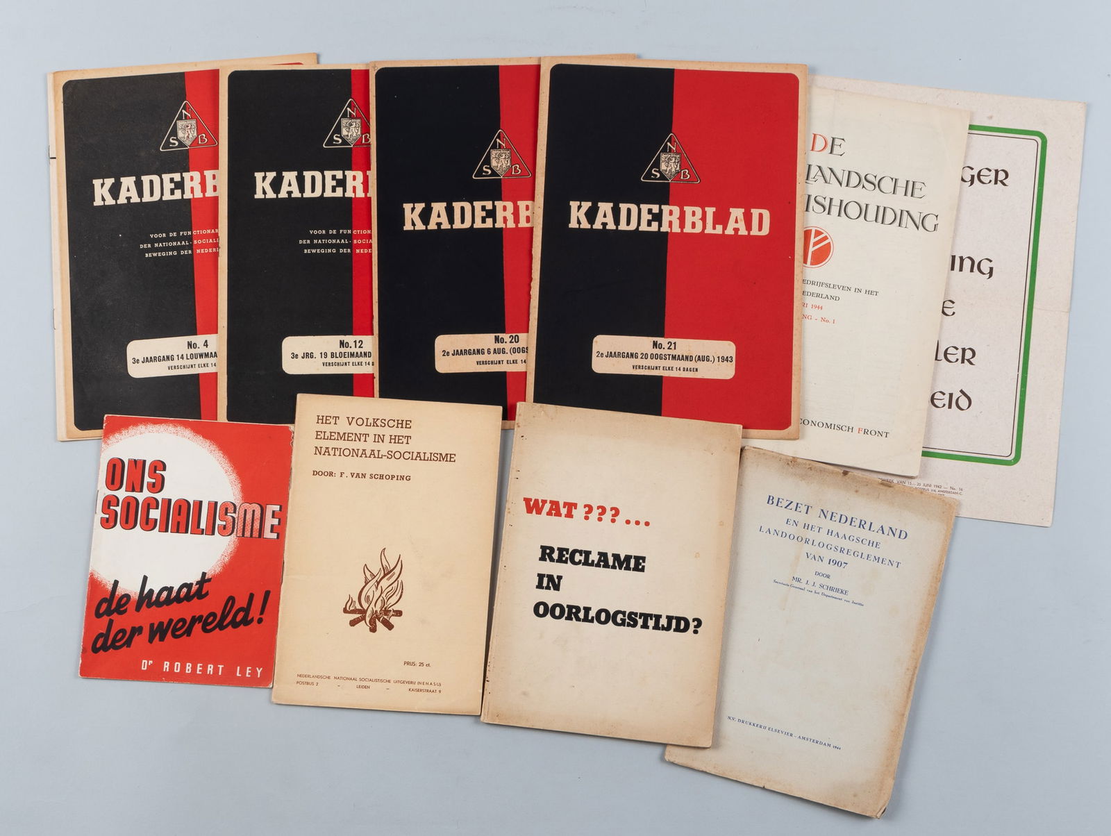 WWII DUTCH LITERATURE [NSB]: Grouping of WWII Dutch [NSB] Literature, including five Kaderblad magazines, an internal monthly education magazine for high-ranking officials, a weekly propaganda poster to boost worker morale