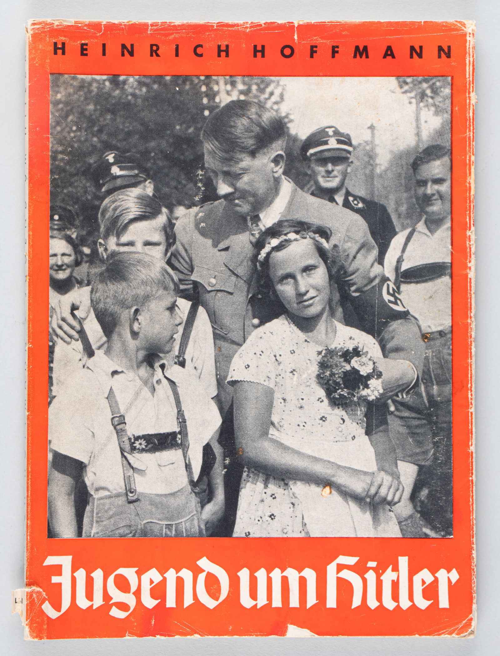 HITLER YOUTH / JUGEND UM HITLER BY HEINRICH HOFFMANN: Hitler Youth 'Jugend um Hitler' book by Heinrich Hoffmann, 1935, Verlag Heinrich Hoffmann, Munchen. 96 pages of photographs taken by Hoffmann, with the original dust jacket. Tearing to the dust cover.