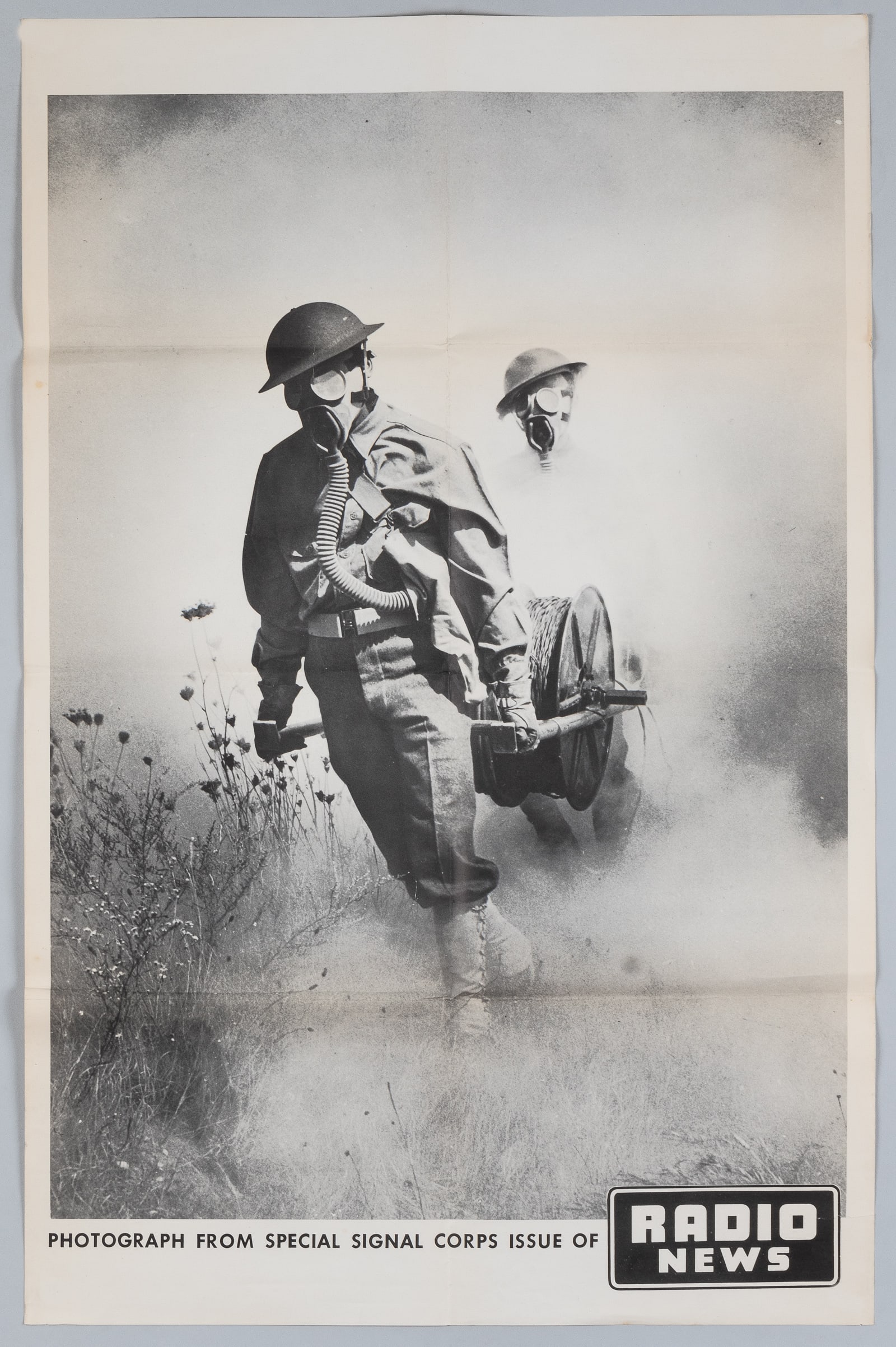 UNDER FIRE - WWII SIGNAL CORPS RADIO NEWS POSTER: UNDER FIRE - Large WWII poster featuring a 'Photograph from Special Signal Corps issue of Radio News.' The original photograph by an unidentified photographer was published in the Radio News magazine 