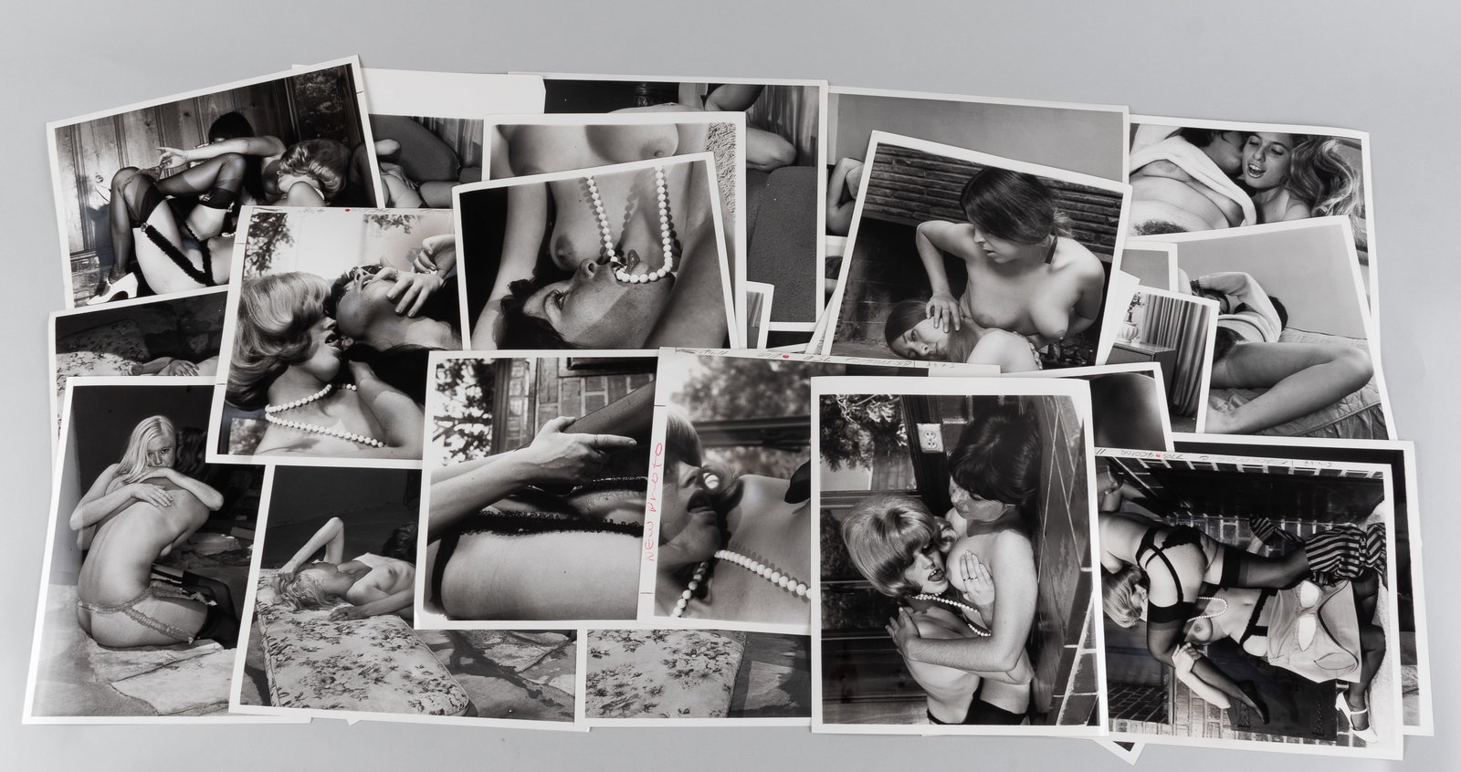 32 VINTAGE ADULT EROTIC LESBIAN PHOTOGRAPHS: Thirty-two vintage b/w adult lesbian erotic photographs, all from professional scenes, likely intended for magazine publishing, all with performer names on the reverse, two with crop marks and instruc