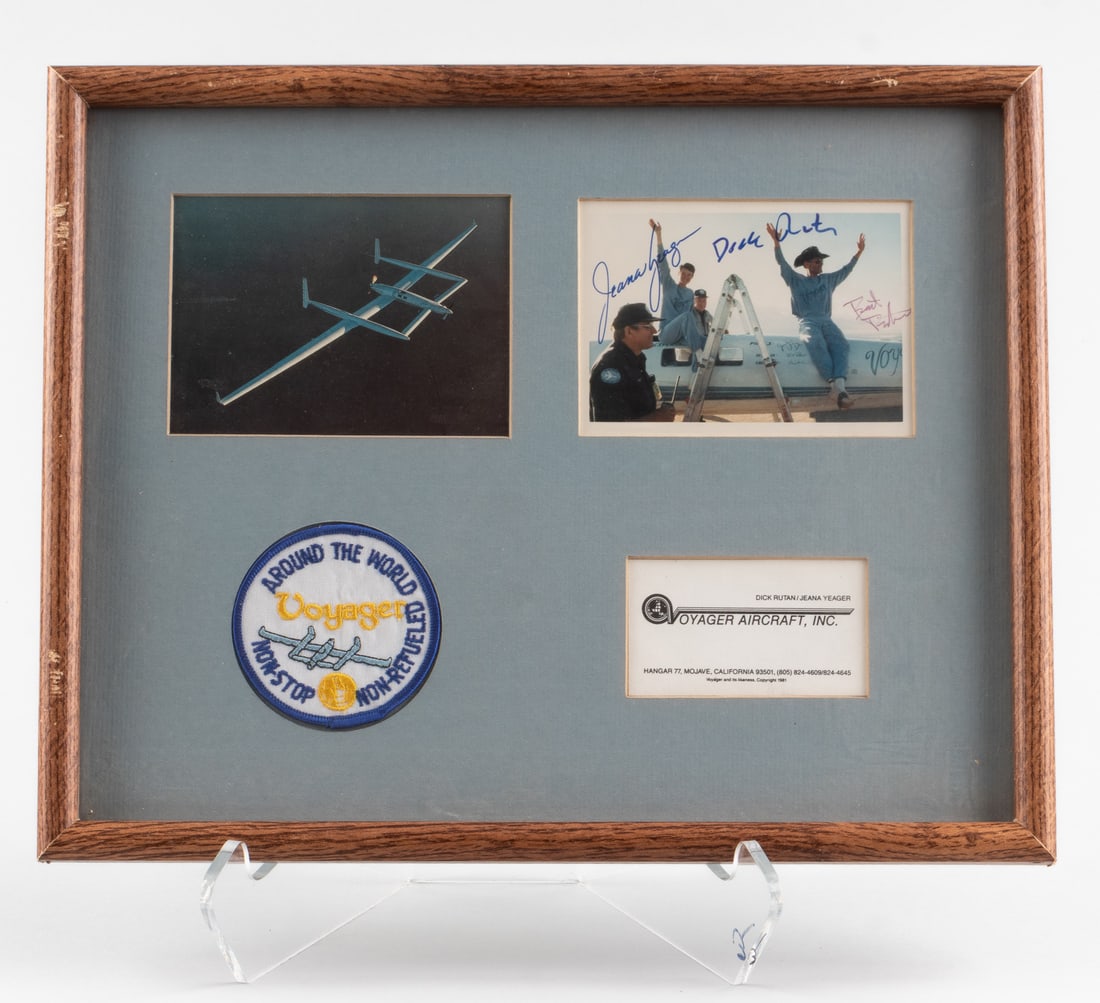 DICK RUTAN AND JEANA YEAGER - VOYAGER AROUND THE WORLD: Dick Rutan and Jeana Yeager - Voyager Around The World. Photograph signed by Dick Rutan and Jeana Yeager. 3.5 x 5 inches. In a framed display with an original Voyager cloth patch, a business card