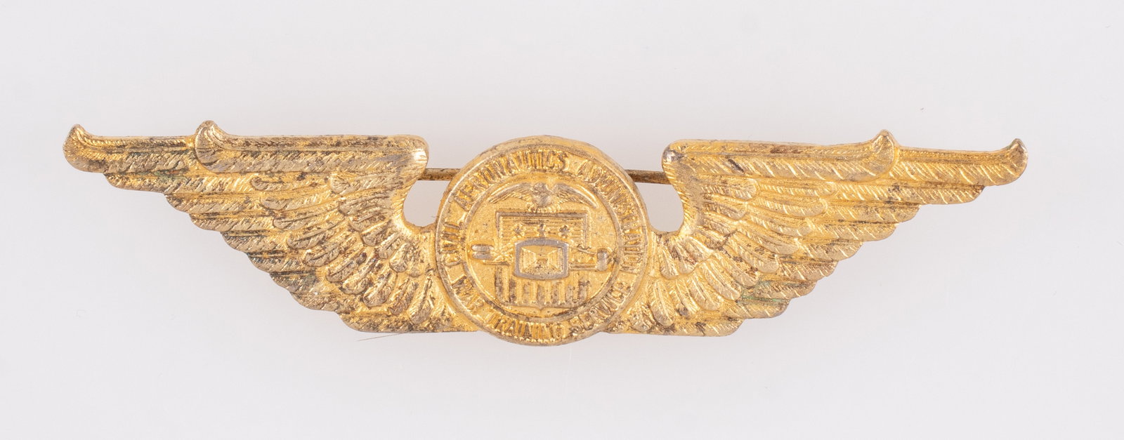 WWII CAA WAR TRAINING STERLING WINGS IN GOLD: WWII-era US Civil Aeronautics Administration War Training Service sterling pilot wings badge in gold, c-clasp pinback, marked sterling on the reverse, 3 inches long.