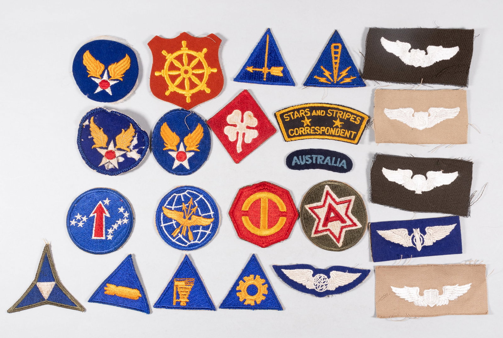 23 WWII AMERICAN INSIGNIA PATCHES: Twenty-three WWII American insignia patches, US Army Air Force patches include: three Hap Arnold patches, one with button attachments sewn onto the reverse, a Communications Specialist patch, a