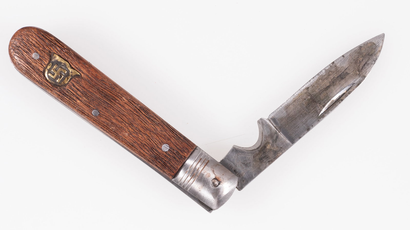 SWASTIKA POCKET KNIFE: Folding pocket knife; the blade is marked 'PUMA - SOLINGEN,' with a 3.5-inch blade, wood grips with a swastika button inset on one end of the grip. As-is.