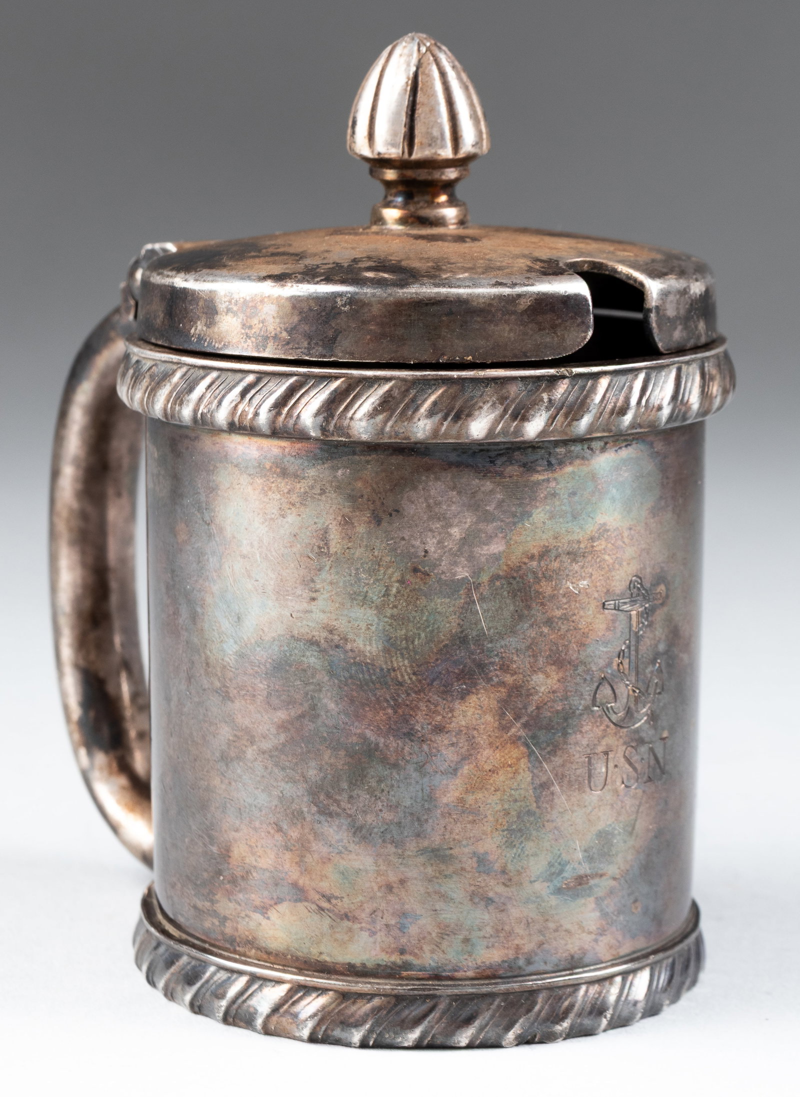 US NAVY SILVER PLATED MUSTARD POT: United States Navy silver-plated captains' mess hall mustard pot. Engraved on the front: 'USN' with a fouled anchor insignia; on the bottom: 'International Silver Company Silver Soldered 01325.' 3.75 