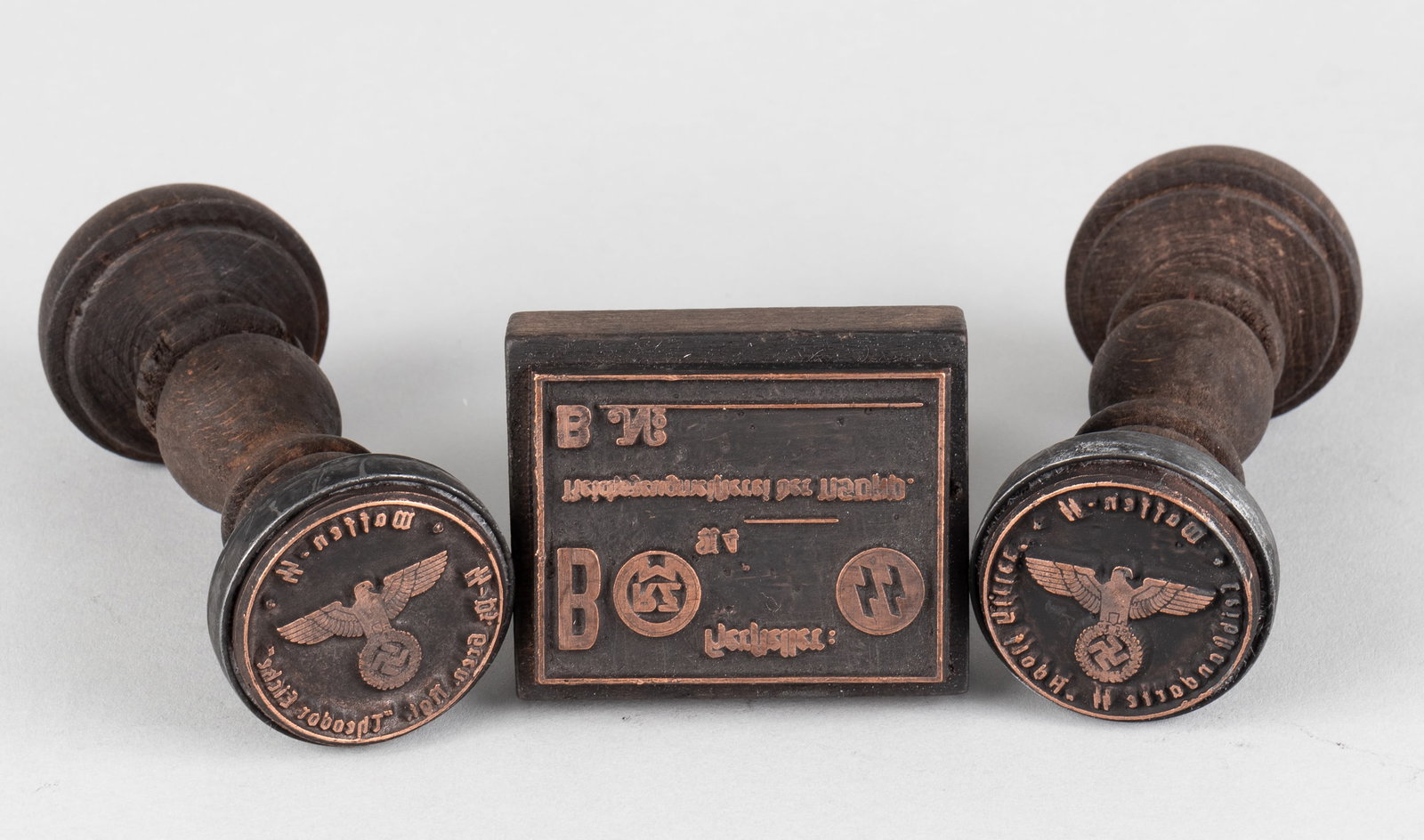 THREE WAFFEN-SS HANDSTAMPS: Three Waffen-SS wooden handstamps; one reads 'Waffen-SS 2. SS-PZ. Gre. Rgt. Theodor Eicke Leibstandarte SS- Adolf Hitler' with a Reichsadler eagle in the center; one reads 'SS-Kommando Lager