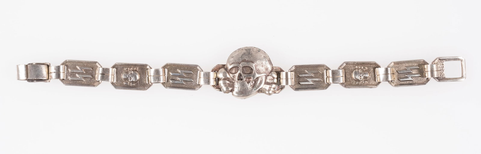 WAFFEN-SS TOTENKOPF BRACELET: Waffen-SS Totenkopf insignia bracelet, with a large Totenkopf skull in the center, and SS runes and a smaller Totenkopf on the bracelet band. On the reverse of one of the links is stamped 'KH,' with
